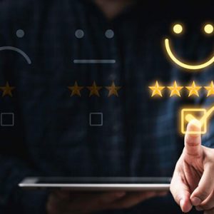 مشتری تبلت را در دست گرفته و علامت تیک روی صورتک مجازی را لمس می کند تا مشتری پس از استفاده محصول و خدمات را ارزیابی کند